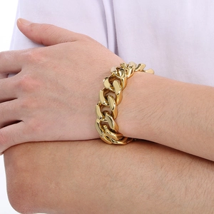 Close-up of a bold golden Cuban link bracelet on a wrist highlighting its metallic finish