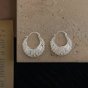 Ethnic hollow silver earrings with filigree pattern on stone and vintage book