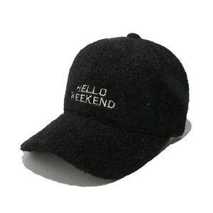 Detailaufnahme der schwarzen Plüschtextur und der weißen HELLO WEEKEND Stickerei auf der Kappe