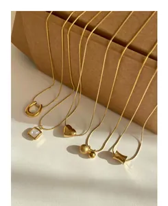 Detailed display of five gold titanium steel necklaces with diverse minimalist pendants