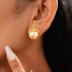 Detailed close-up of a champagne gold pearl earring with a zircon floral border