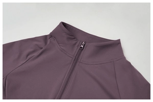 Détail de la fermeture éclair et du col montant de cette veste de yoga violette brossée