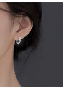 Macro detail of S999 sterling silver C-shaped earring with textured crushed silver finish