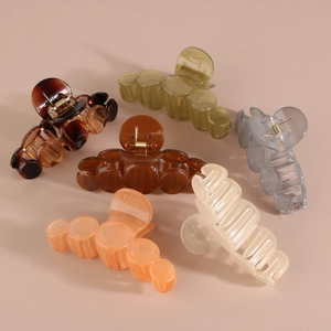 Detailed view of assorted multi-colored glossy PS material hair claws on neutral background
