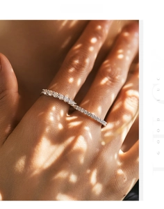 Close-up of S925 sterling silver eternity band with moissanite stones on a model hand