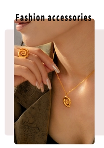Close-up of elegant gold spiral jewelry set featuring a necklace and ring on a model