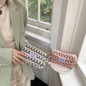 Détail d'une trousse à maquillage en velours côtelé fleuri avec fermeture éclair