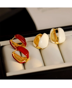 Detail of French vintage gold hoop earrings with red and white enamel glazed drops