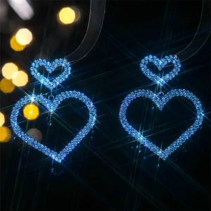 Macro detail of luxury blue heart-shaped earrings with sparkling rhinestone crystals