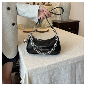 Detail of black leather crescent bag featuring chunky silver chain and star-shaped hardware