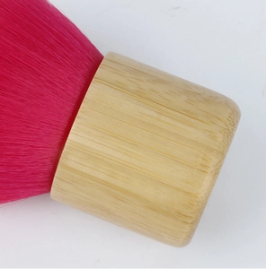 Macro shot of fluffy pink bristles and natural bamboo handle of this multi-use makeup brush