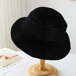 Minimalist black crochet sun hat on a wooden stand with a breathable woven mesh design