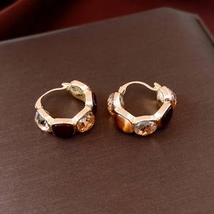 Macro detail of vintage square earrings with champagne and brown crystal inlay in gold finish