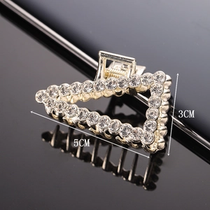 Macro view of triangular hair claw with shimmering rhinestones and size dimensions
