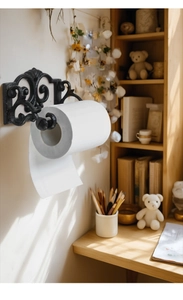 Detail of vintage cast iron paper towel holder with classical scrollwork on a wall