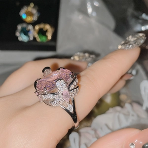 Close-up of a luxury 18k silver-plated ring with large pink gemstone and bow design