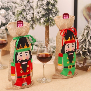 Detailed view of linen nutcracker wine bottle covers in festive red and green colors
