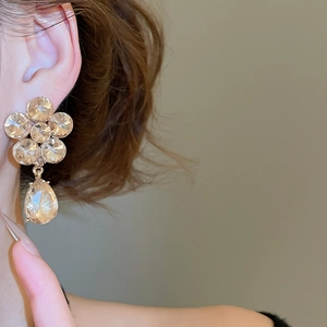Macro shot of sparkling flower drop earrings with rhinestones and silver pins