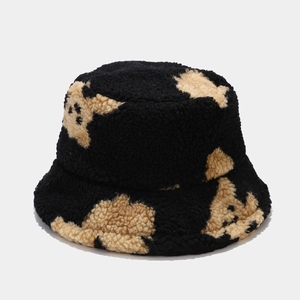 Detailed view of black fuzzy sherpa bucket hat with cute khaki bear pattern texture