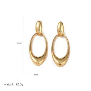 Detail view of large gold-tone earrings showing size dimensions 6.6cm by 2.4cm