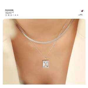 Detail of silver double-layered chain necklace with a rectangular zircon pendant