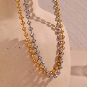 Detailed macro view of 4mm ball chain necklaces in polished gold and silver steel finish