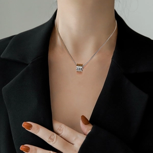 Minimalist silver titanium steel triple-ring cylinder pendant necklace on model's neck