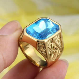 Macro view of blue gemstone gold ring with Freemason symbol and detailed embossing