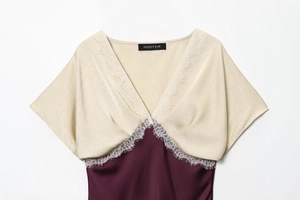 Detail of burgundy satin dress with cream jacquard bodice and delicate lace trim