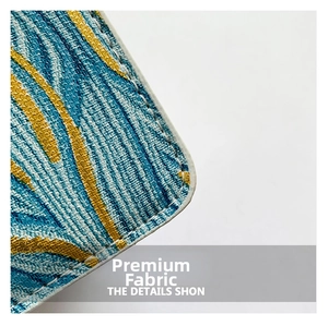 Macro shot of embroidered fabric with blue-yellow patterns and precise white stitching