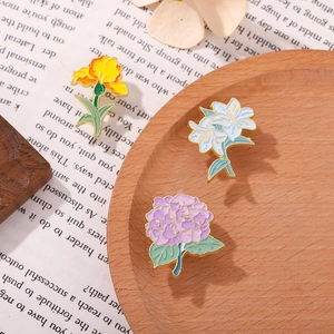 Exquisite floral enamel brooch set featuring yellow iris, blue lily, and purple hydrangea