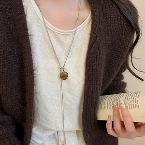 Detailed view of heart-shaped tiger eye stone pendant on a long silver necklace chain