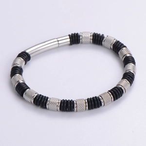 Macro detail of men's stainless steel woven bracelet with black rubber and knurled metal beads