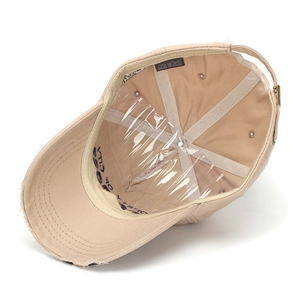 Close-up of beige cotton baseball cap interior with distressed brim and metal buckle
