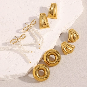 Detail showing 18K gold-plated vintage earrings with pearls on white matte stone
