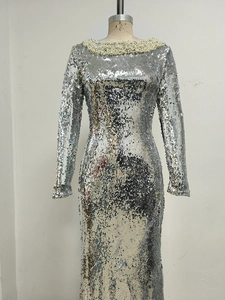 Close-up of silver sequin fabric and pearl neckline detail on long sleeve evening gown