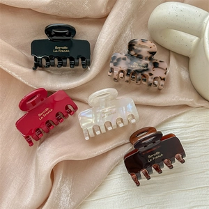 Five assorted colors of acetate hair claws on elegant satin with Borrette La France text