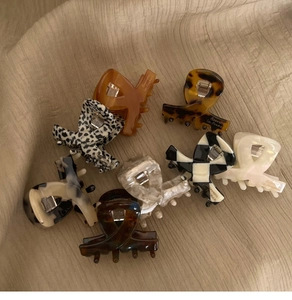Assorted acetate hair claws featuring tortoise shell, checkerboard, and marble patterns