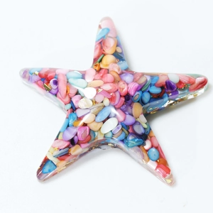 Starfish resin craft with colorful crushed crystals and gold foil on white background