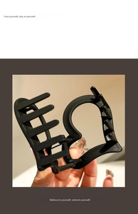 Detail of a matte black hollow heart claw clip showing the strong metal spring mechanism