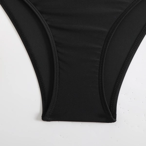 Detailaufnahme des schwarzen Badeanzugstoffs mit präziser Doppelnaht und hoher Elastizität