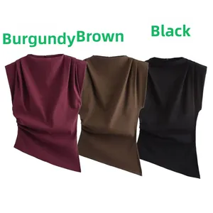 Detail of pleated neckline and asymmetrical hem on sleeveless tops in three colors