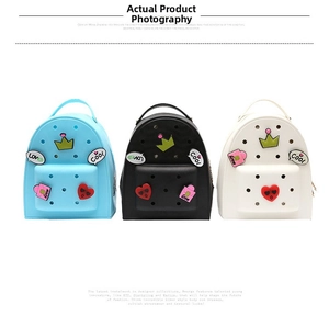 Three mini silicone backpacks in blue, black, and white with DIY charms and top handles