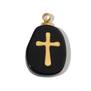 Macro shot of oval black natural stone pendant with gold cross and stainless steel loop