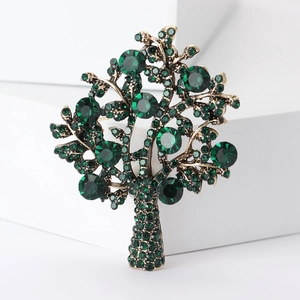 Macro detail of money tree brooch with green rhinestones on antique bronze metal base