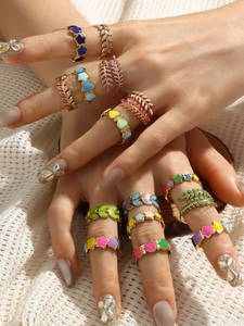 Close-up of colorful enamel heart and star rings in 18k gold plating on model's hand