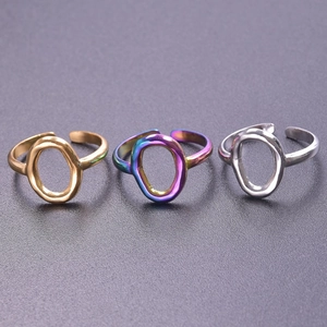 Detailed view of three open titanium steel geometric rings in gold, silver and neon colors