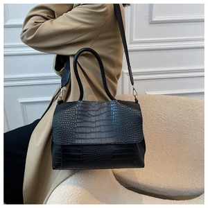 Detail of black crocodile pattern PU leather tote bag with wide shoulder strap