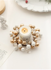 Detailed view of beaded Christmas candle ring with gold ornaments and glass holder
