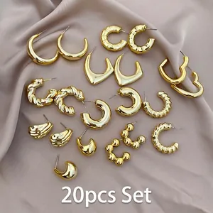 Detailed flat lay of a 20-piece golden earring set on soft champagne silk fabric